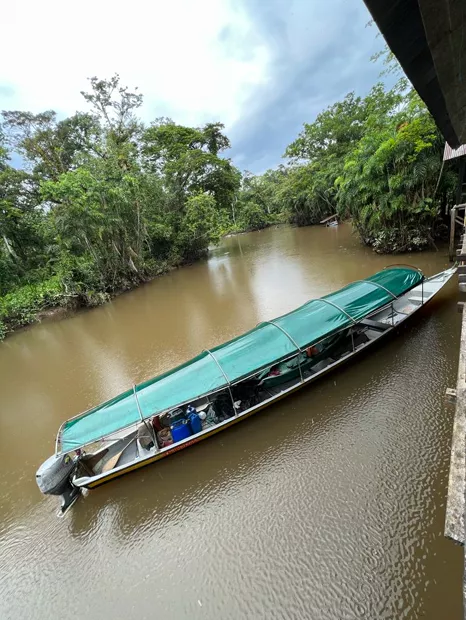 Long covered boat moored on the muddy Napo