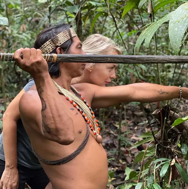 Waorani man teaching a visitor to aim a blowgun