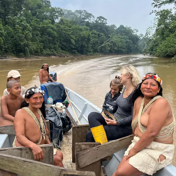 Waorani family and travelers sharing the boat back