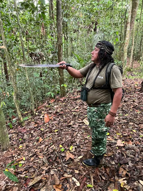 Waorani guide holding a machete on a forest trail