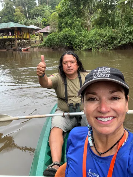 Guide and traveler paddling and smiling in a canoe