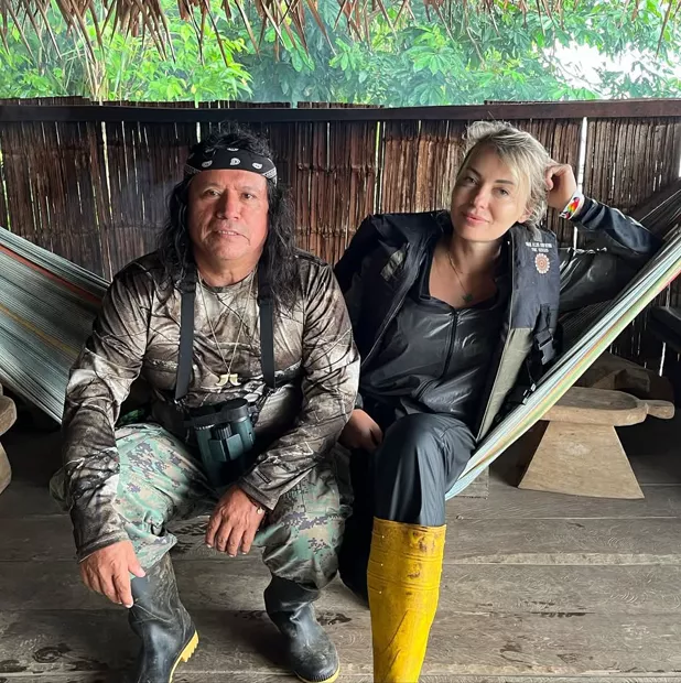 Couple relaxing in a hammock next to a Waorani guide