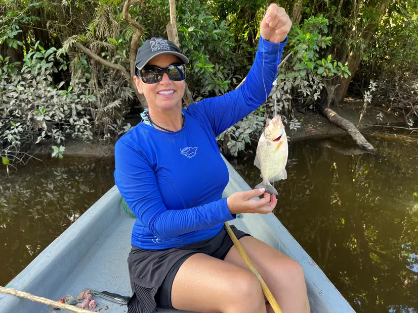 Visitor proudly holding up a fish caught on the trip