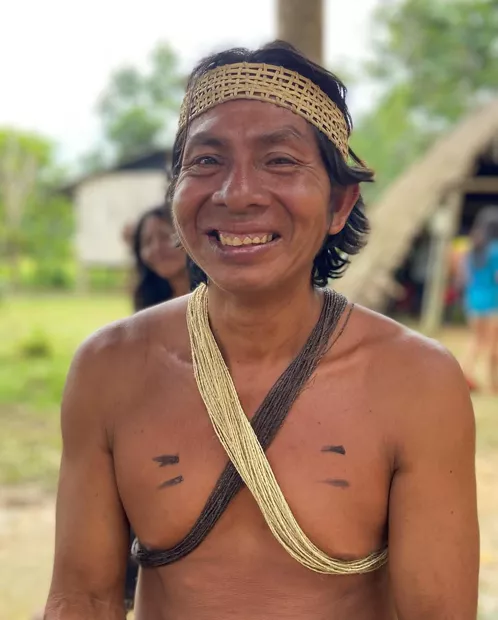 Portrait of a smiling Waorani man with a woven crown